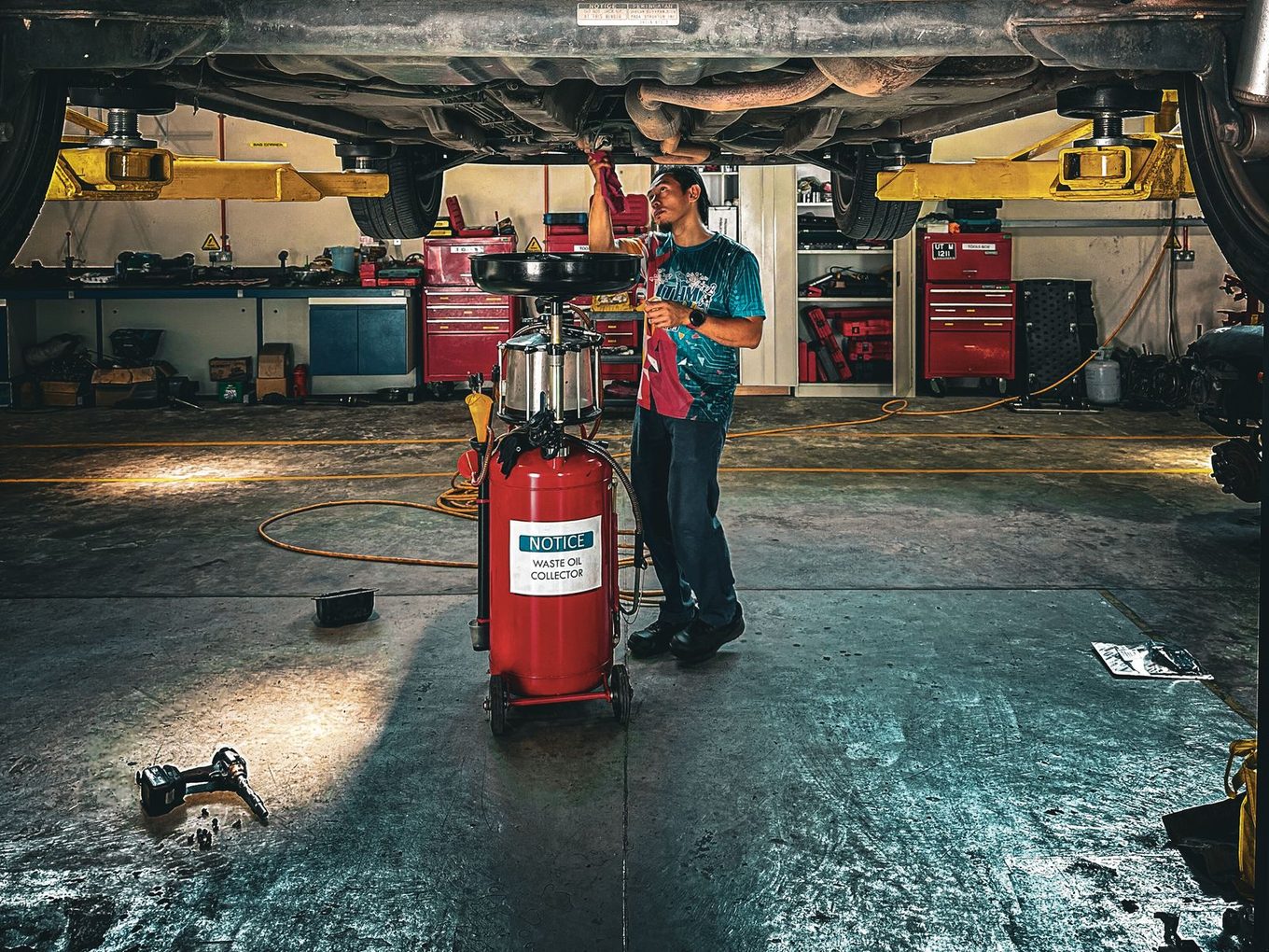 Mechanic working under a car on a lift
